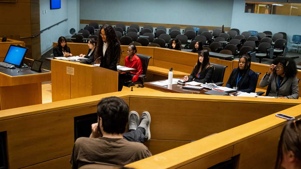 a student stands at a podium in a courtroom