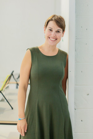 Novotny leaning against wall in green dress